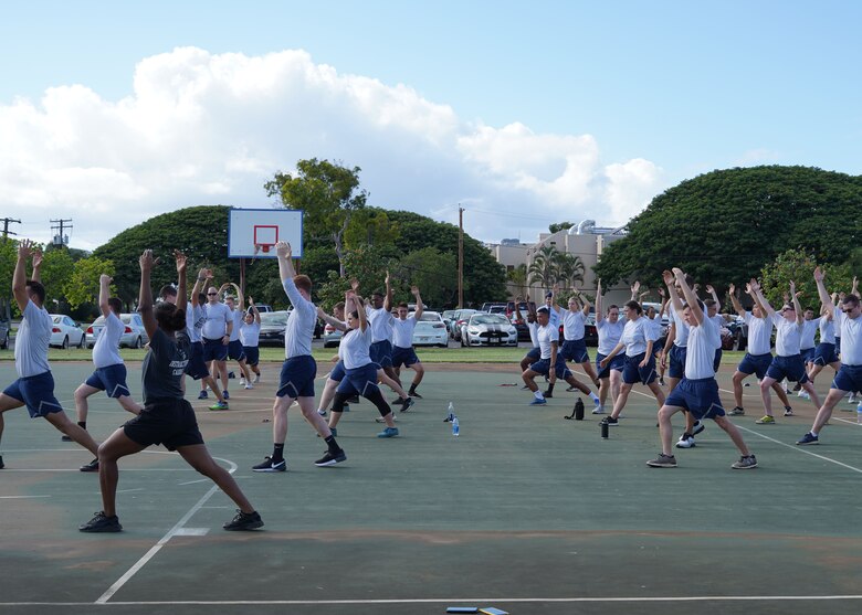 Airmen in the Airman Leadership School perform cool-down stretches following physical training at Joint Base Pearl Harbor-Hickam, Hawaii, Oct. 28, 2019. Airman Leadership School is a preparatory course for Airmen to learn leadership and critical-thinking skills. (U.S. Air Force photo by Airman 1st Class Erin Baxter)