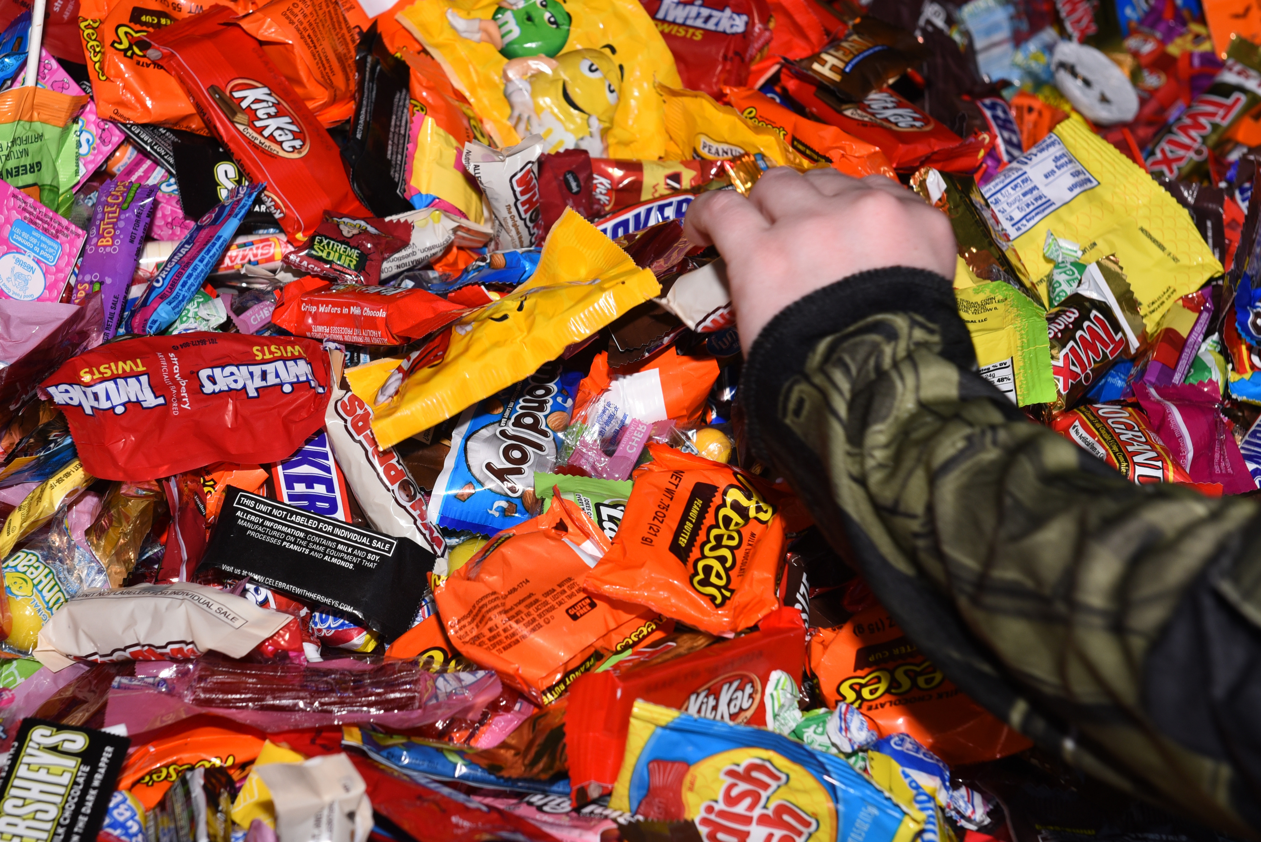 A child attending the Trunk-or-Treat event grabs candy out of a trunk Oct. 25, 2019, at Travis Air Force Base, California. The Airman and Family Readiness Center hosted Trunk-or-Treat, an annual event aimed to provide a safe place for military families to enjoy Halloween festivities. The event had approximately 5,000 attendees and more than 60 vehicles trunks loaded with candy. (U.S. Air Force photo by Airman 1st Class Cameron Otte)