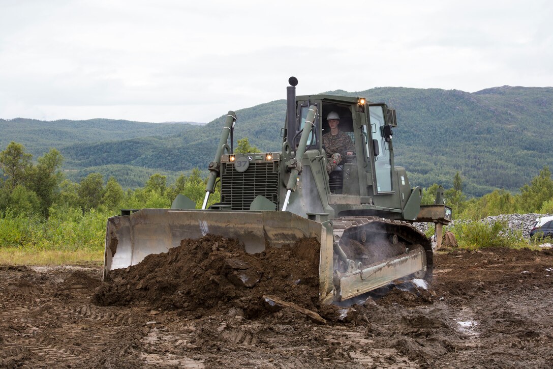 A U.S. Marine with II Marine Expeditionary Force, uses a medium crawler tractor to move rocks during a heavy equipment operation in Setermoen, Norway, Aug. 22, 2019.