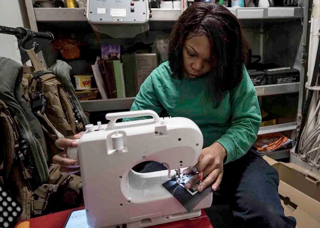 Image of female sailor using a sewing machine