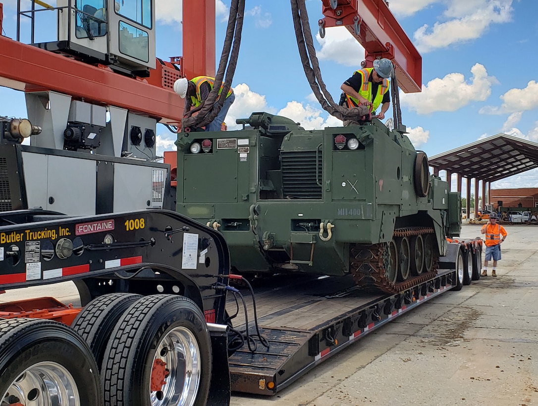 Civilian-Marines and Defense Logistics Agency employees load an M9 Armored Combat Earthmover at Marine Corps Logistics Base Albany.  Marine Corps Logistics Command and DLA worked together to ship several M9 combat excavators in order to serve training needs in California and Nevada.
