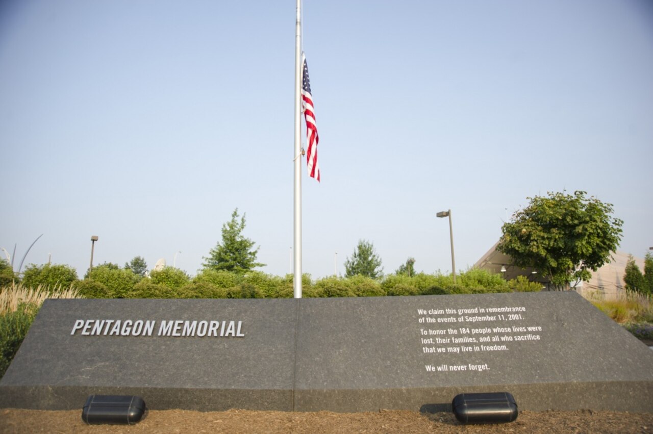 The 9/11 Pentagon Memorial entrance with an American flag flying at half-staff.