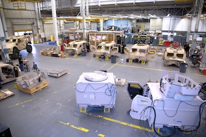 Image of warehouse action with MRAP parts placed in bays.