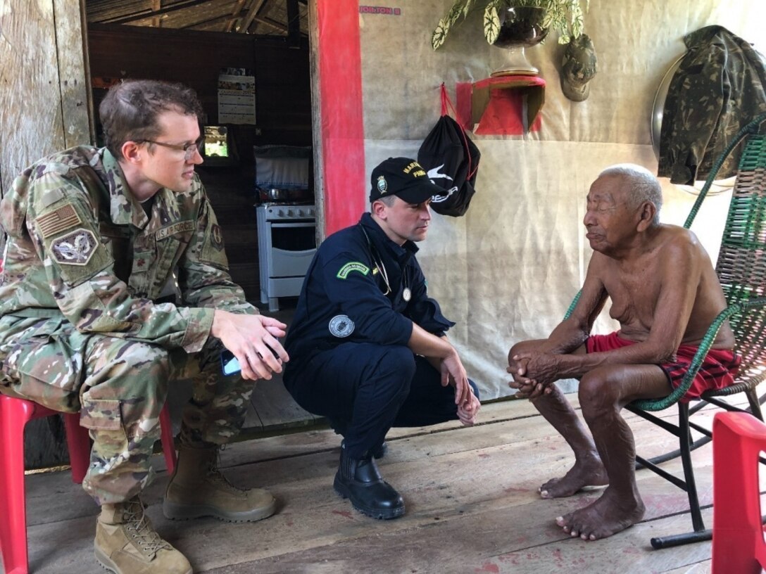 Military doctors speak to a patient.
