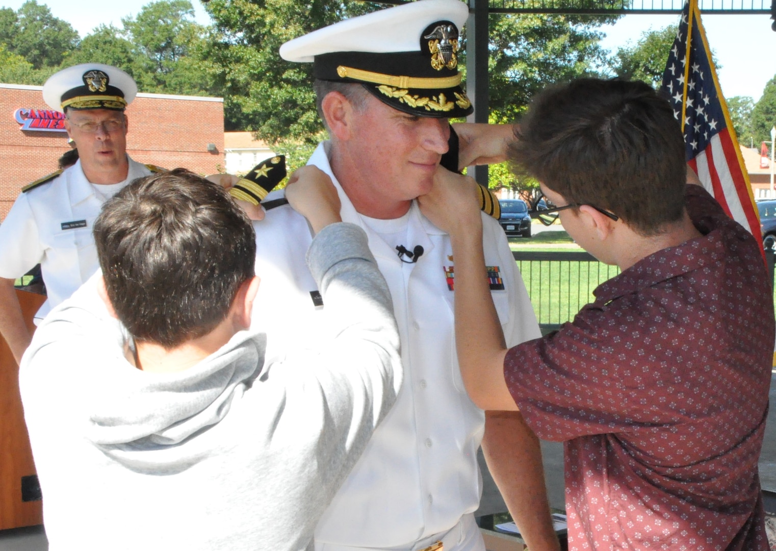 IMAGE: DAHLGREN, Va. (Aug. 30, 2019) – Quinn and Elijah Plew attach new shoulder boards on their father, Capt. Casey Plew, during his promotion ceremony at Naval Surface Warfare Center Dahlgren Division (NSWCDD). It was Plew’s second ceremony marking a career milestone in four months. The new Navy captain took command of NSWCDD – the Naval Sea System Command’s largest Naval Warfare Center – at a ceremony held on the Potomac River Test Range in April.