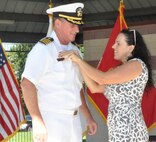 IMAGE: DAHLGREN, Va. (Aug. 30, 2019) – Carolina Plew pins a new name tag on her husband, Capt. Casey Plew, during his promotion ceremony at Naval Surface Warfare Center Dahlgren Division (NSWCDD). It was Plew’s second ceremony marking a career milestone in four months. The new Navy captain took command of NSWCDD – the Naval Sea System Command’s largest Naval Warfare Center – at a ceremony held on the Potomac River Test Range in April.