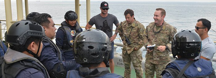 U.S. Coast Guard Maritime Enforcement Specialists debrief Malaysian Maritime Enforcement Agency coast guardsmen after a visit, board, search and seizure training.