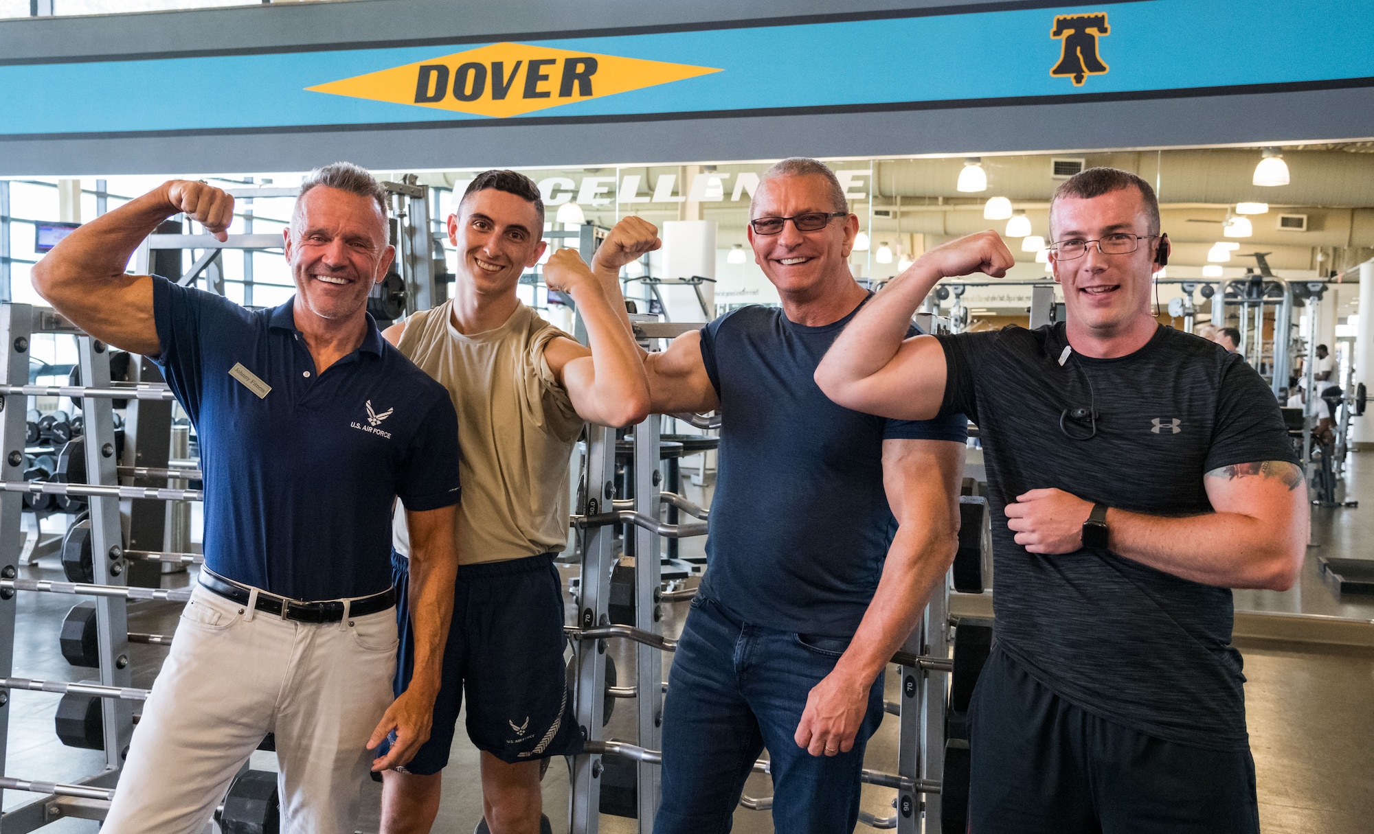 From left to right, John Walters, 436th Force Support Squadron fitness program manager; Airman 1st Class Rodney Kerley, 436th Communications Squadron cybersystems operator; chef Robert Irvine and Tech. Sgt. Heath Hackwell, 436th Maintenance Group maintenance qualification training program noncommissioned officer in charge of instructors, flex their biceps, Aug. 27, 2019, at the Fitness Center on Dover Air Force Base, Del. Irvine talked with Airmen during his tour of the facility. (U.S. Air Force photo by Roland Balik)