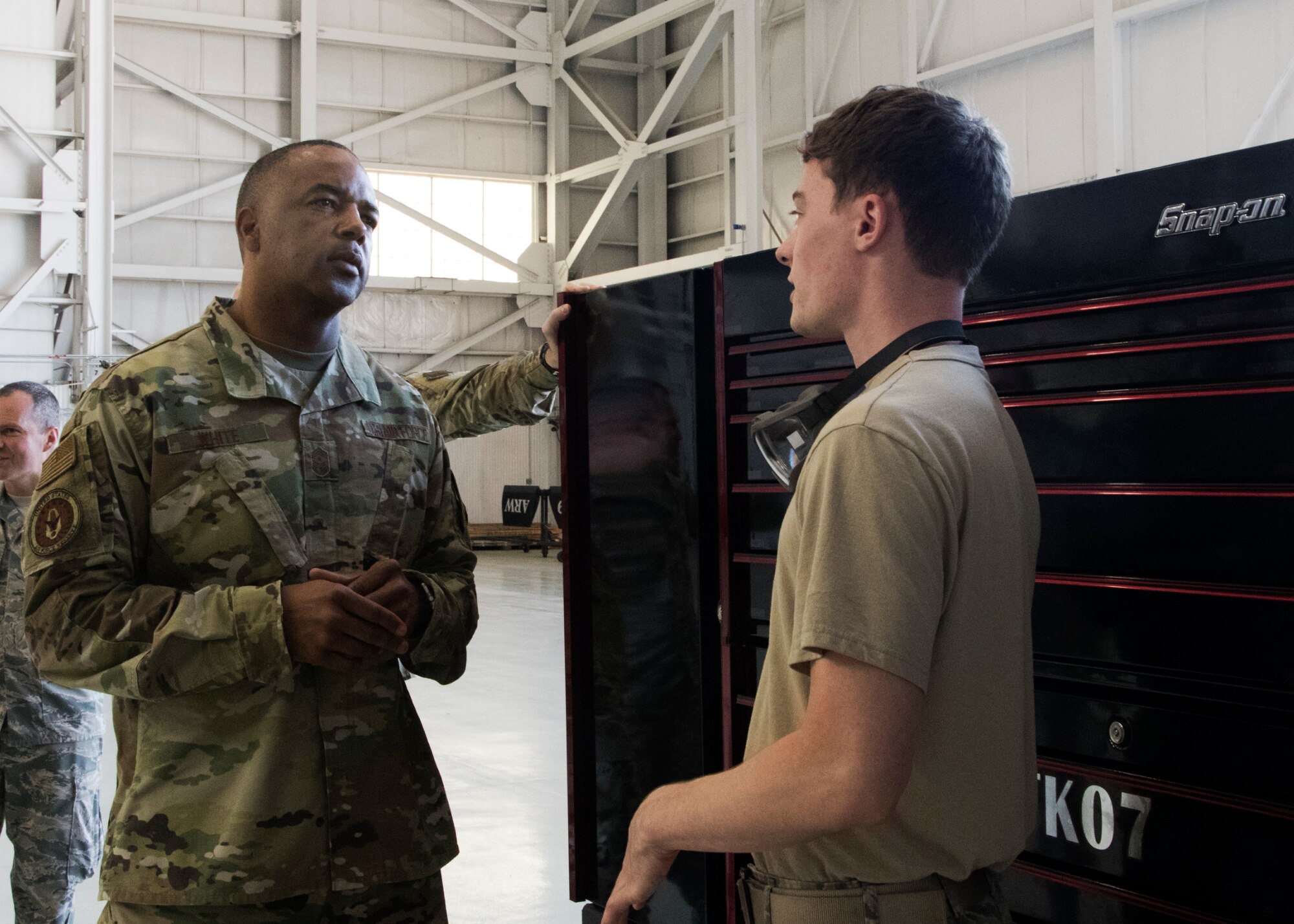 Chief Master Sergeant Timothy White, Air Force Reserve Command command chief, speaks with an Airman from the 459th Maintenance Group during a visit to the wing Aug. 12, 2019, at Joint Base Andrews, Md. White accompanied Chief Master Sgt. of the Air Force Kaleth O. Wright and Joint Base Andrews leadership as they toured units from around the installation. (U.S. Air Force photo by Staff Sgt. Cierra Presentado/Released)