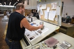 Everett E. (Skip) Craig Jr., press operator at KB Offset Printing Inc. in State College, Pennsylvania, measures the degree of darkness of the reflecting surface on a page of Loglines magazine during the final press run Aug. 26. The magazine’s print version ends with the September/October 2019 issue. Photo by Phil Prater