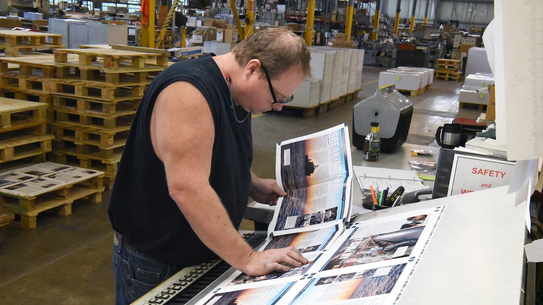 Everett E. (Skip) Craig Jr., press operator at KB Offset Printing Inc. in State College, Pennsylvania, compares the print quality from several print runs of Loglines to ensure consistency. Photo by Phil Prater