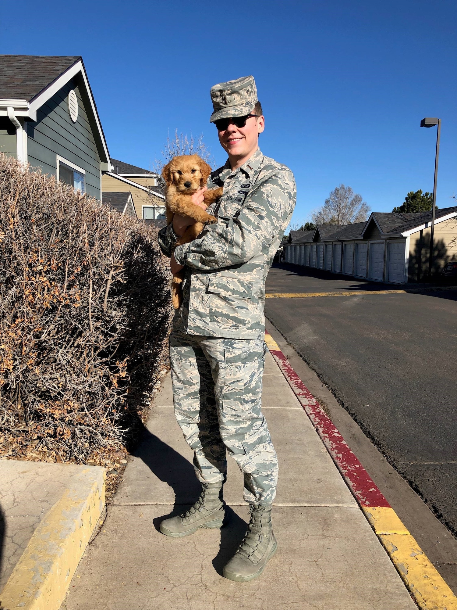 2nd Lt. Justin Davidson-Beebe, 21st Space Wing public affairs officer, poses for a photo with his dog Butters March 20, 2019 at Peterson Air Force Base, Colorado. He said that Butters and the other dogs he’s had through his life help him maintain his resilience because of their innate enthusiasm. (U.S. Air Force courtesy photo)