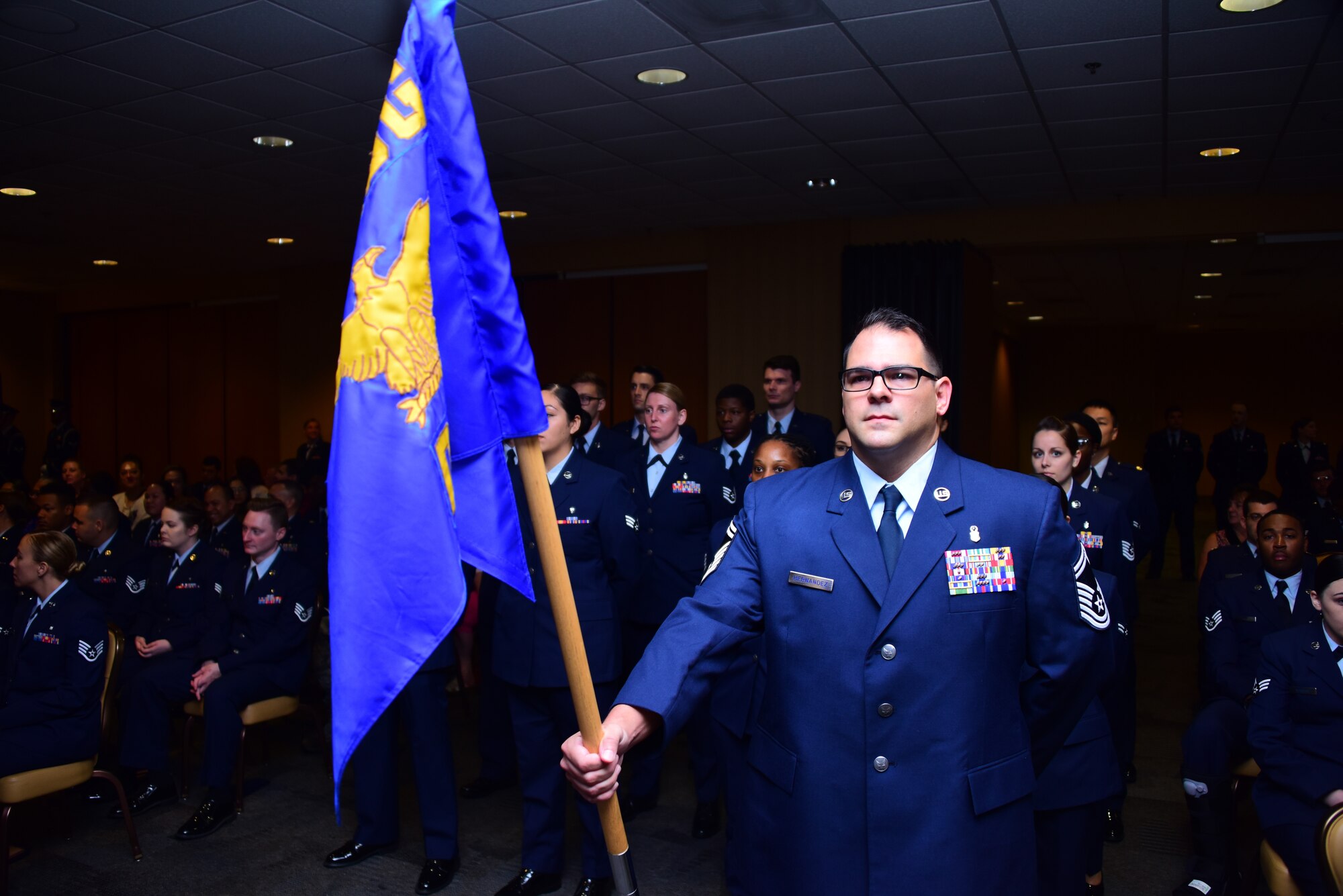 a photo of an airman holding the medical group guidon for a ceremony
