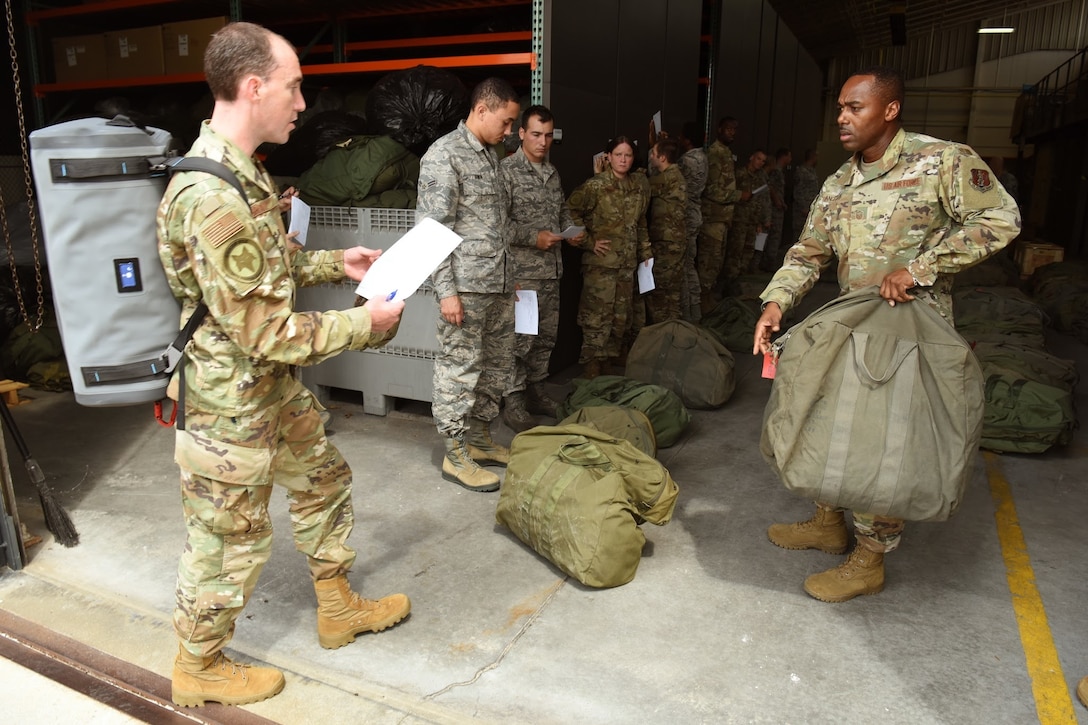 Master Sgt. Lamar Anderson, 169th Logistics Readiness Squadron, right, issues equipment to the initial group of 32 Airmen from the South Carolina Air National Guard's 169th Fighter Wing at McEntire Joint National Guard Base, Eastover, S.C. as they prepare to depart for Bluffton, SC., Sept. 1, 2019. Once there, they will provide Hurricane Dorian response support to civilian partners. South Carolina National Guard Soldiers and Airmen from units across the state prepare to respond as needed, in support of the potential impact of Hurricane Dorian to the state. (U.S. Air National Guard photo by Senior Master Sgt. Edward Snyder, 169th Fighter Wing Public Affairs)