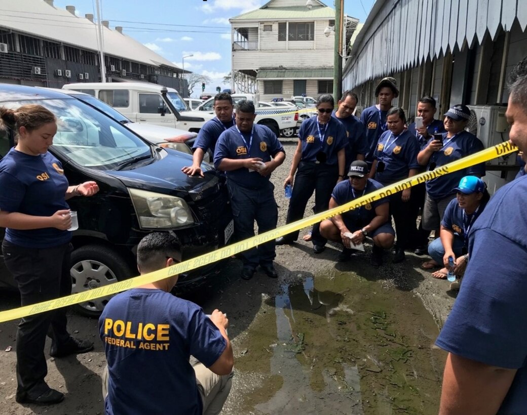 Special Agent Michelle Kiyota, left, explains the proper use of dental stone, which enables the recovery of footprints, during the AFOSI FIR 6 SMB Subject Matter Expert Exchange with Samoan law enforcement partners Aug. 20-22, 2019. (FIR 6/SMB photo)