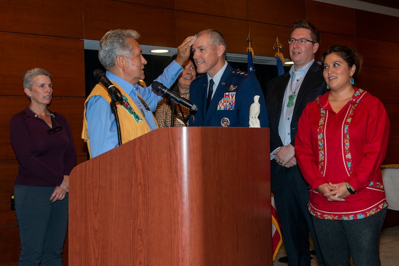 Ed Thomas, Sealaska Board of Directors member, presents a Tlingit name to U.S. Air Force Lt. Gen. Thomas Bussiere, commander, Alaskan North American Aerospace Defense Command Region, North American Aerospace Defense Command; commander, Alaskan Command, U.S. Northern Command; and commander, 11th Air Force, Pacific Air Forces, during an Alaska Native naming ceremony on Joint Base Elmendorf-Richardson, Alaska, Aug. 28, 2019. The AFN hosted the event honoring Bussiere for his service and his active engagement with the Alaska Native community during his tenure in Alaska. The naming ceremony is based on the traditional belief that a person’s name is the type of soul they possess. The ceremony showcased the bond between the Alaska Native community and the military in Alaska.