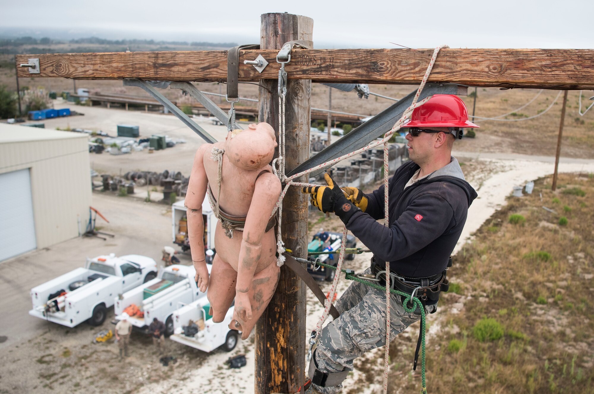 Senior Airman Rafal Waledziak, 30th Civil Engineer Squadron electrician, retrieves a dummy from atop a power pole during pole-top rescue training Aug. 23, 2019, at Vandenberg Air Force Base, Calif. During the training, each service member had four minutes to climb a power pole, retrieve a dummy, and hoist the dummy safely to the ground. The Airmen utilize this training to learn the techniques necessary to perform emergency pole-top rescues.  (U.S. Air Force photo by Hanah Abercrombie)