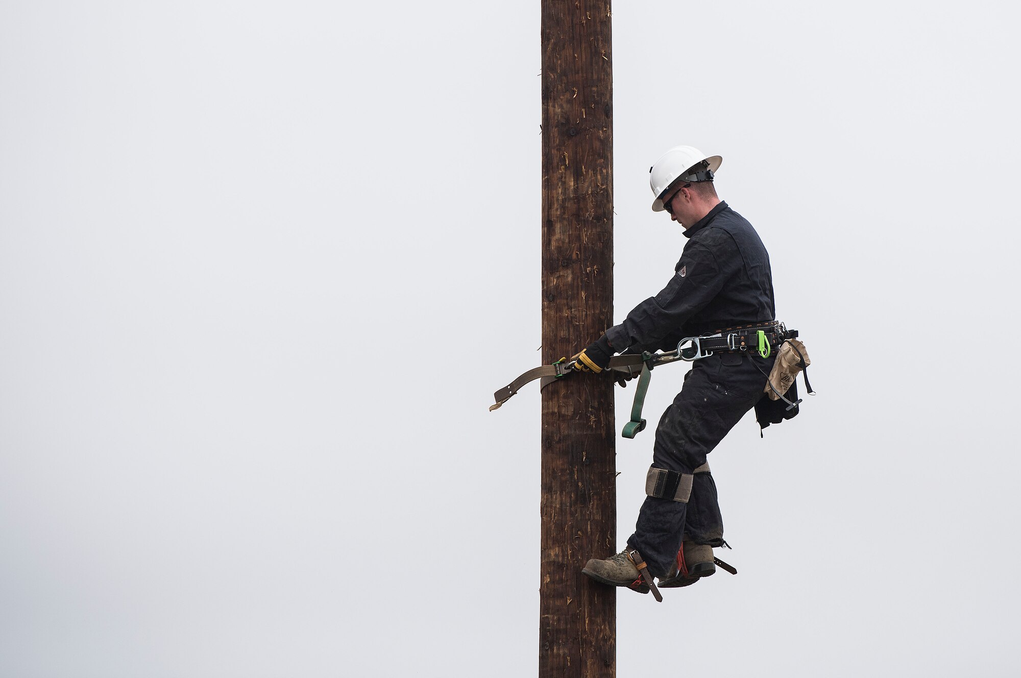 Staff Sgt. Lonnie Elliott, 30th Civil Engineer Squadron electrician, climbs a power pole during pole-top rescue training Aug. 23, 2019, at Vandenberg Air Force Base, Calif. During the training, each service member had four minutes to climb a power pole, retrieve a dummy, and hoist the dummy safely to the ground. The Airmen utilize this training to learn the techniques necessary to perform emergency pole-top rescues. (U.S. Air Force photo by Hanah Abercrombie)