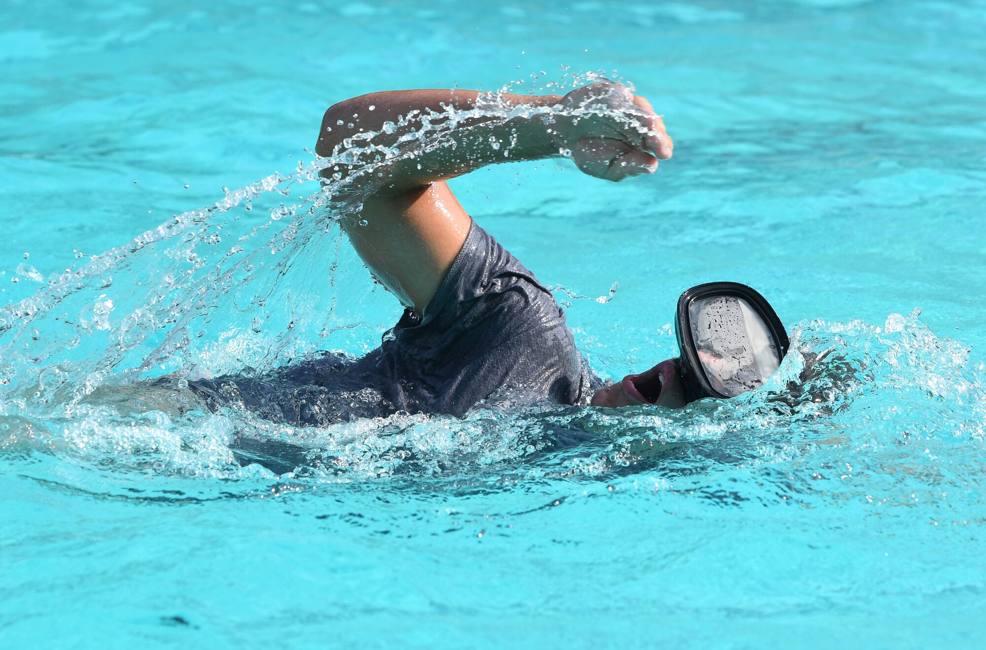 A Special Warfare trainee from the 352nd Special Warfare Training Squadron participates in a memorial physical training session at the Triangle Pool on Keesler Air Force Base, Mississippi, Aug. 9, 2019. The PT event was in memory of U.S. Air Force Staff Sgt. Andrew Harvell, combat controller, who was killed in action on Aug. 6, 2011. Special Warfare trainees also attend courses in the 334th and 335th Training Squadrons. (U.S. Air Force photo illustration by Kemberly Groue)