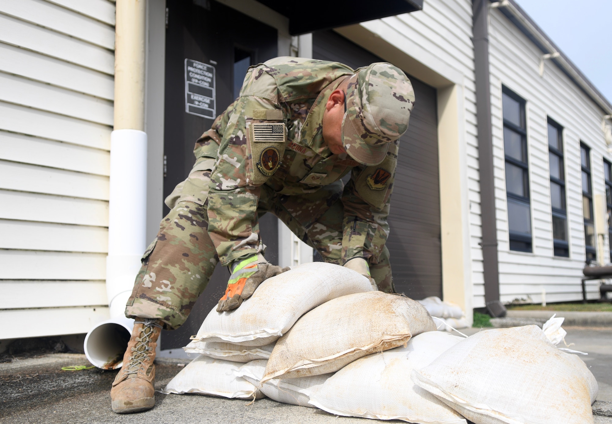 Seymour Johnson Air Force Base, N.C. — SSgt Manuel Acuna, 4th Civil Engineer Squadron pavement and production specialist, stack sand bags in front of a building on the installation Sept. 4, 2019, at Seymour Johnson Air Force Base, North Carolina. The 4th CES, to include equipment operators, electricians, plumbers, structural craftsman, heating, ventilation and air conditioning, and production technicians, are providing 24-hour response and recovery operations during and following Hurricane Dorian. (U.S. Air Force photo by Staff Sgt. Michael Charles)