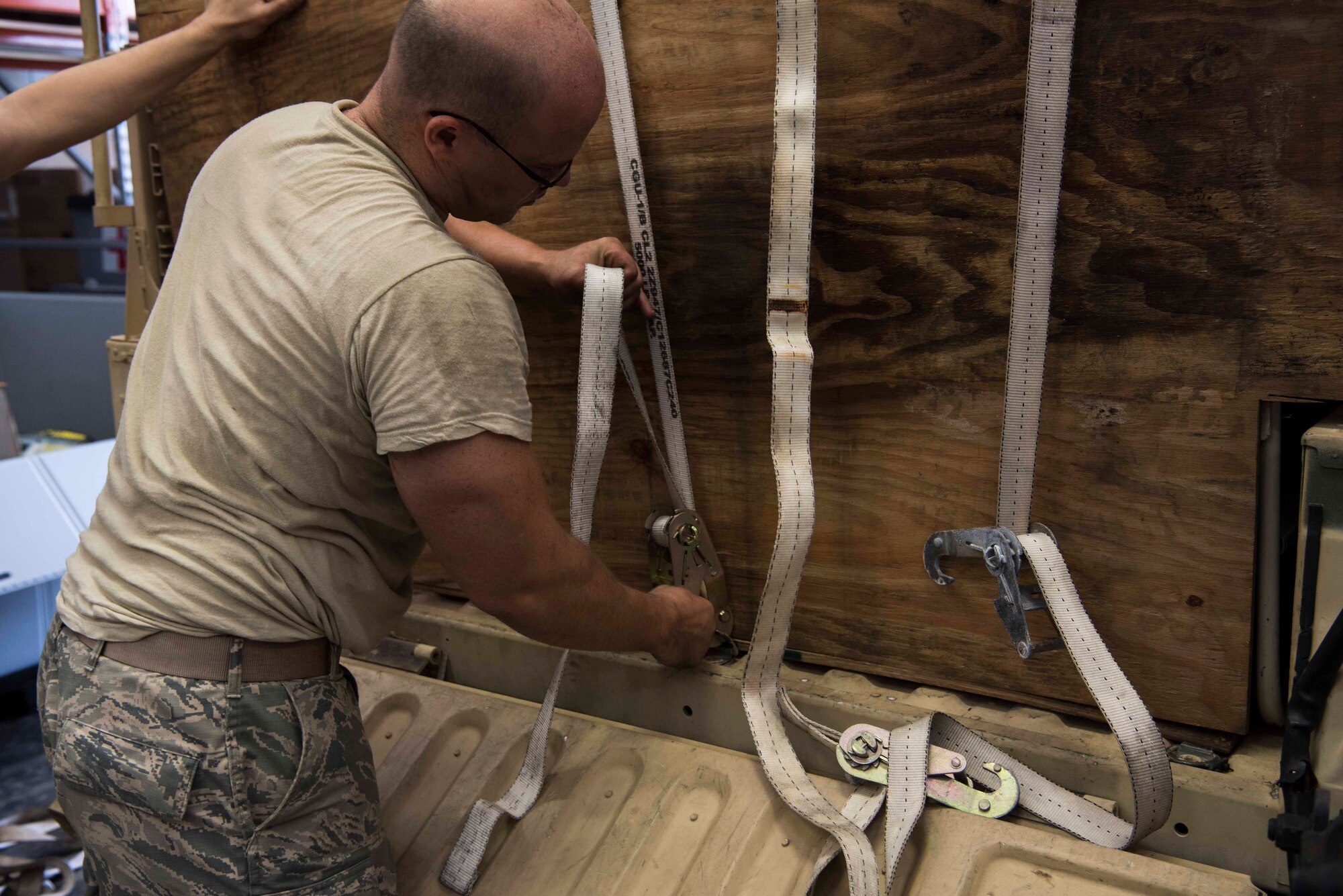 U.S. Air Force Master Sgt. Ursus Vargas, a 6th Medical Support Squadron medical material section chief, uses a ratchet strap to secure cargo at MacDill Air Force Base Fla., Sept. 4, 2019. Cargo included blankets, tents, power generators and assorted health devices. (U.S. Air Force Photo by Senior Airman Frank Rohrig)