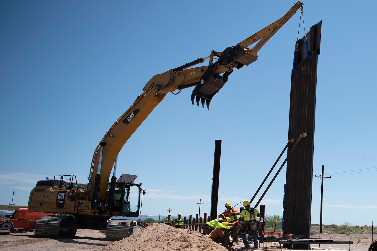Crew members install bollard wall.
