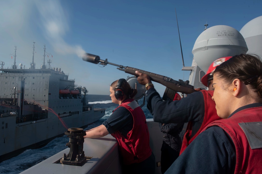 A sailor fires a shot line.