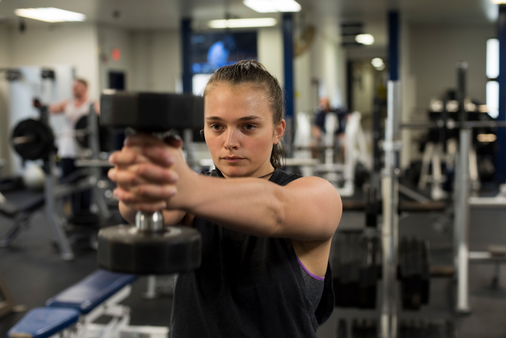 U.S. Air Force Senior Airman Sidnea Bailey, a 35th Operations Support Squadron aircrew flight equipment journeyman, holds a dumbbell at Potter Fitness Center, at Misawa Air Base, Japan, Aug. 11, 2019. In her adolescents Bailey used determination and drive to lose 40 pounds in 3 months by running 2 miles and performing 200 sit-ups a day, enhancing her stamina, flexibility and self-esteem. (U.S. Air Force photo by Senior Airman Collette Brooks)