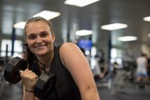 U.S. Air Force Senior Airman Sidnea Bailey, a 35th Operations Support Squadron aircrew flight equipment journeyman, smiles while holding a dumbbell at Potter Fitness Center, at Misawa Air Base, Japan, Aug. 11, 2019. Gaining physical strength while becoming leaner and more confident aided Bailey in becoming the resilient, independent and driven Wild Weasel Airman she is today. (U.S. Air Force photo by Senior Airman Collette Brooks)