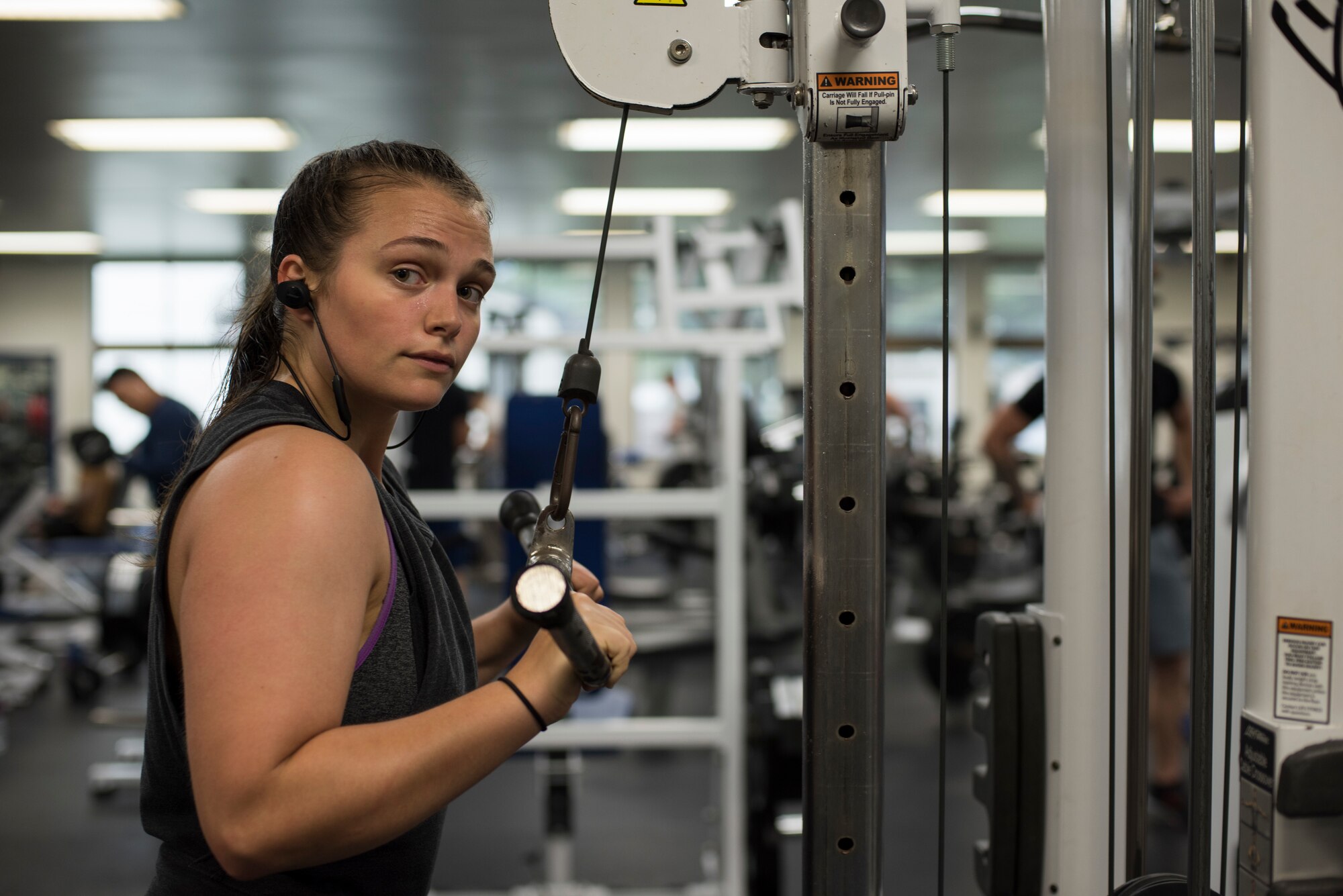 U.S. Air Force Senior Airman Sidnea Bailey, a 35th Operations Support Squadron aircrew flight equipment journeyman, uses a cable crossover machine at Potter Fitness Center, at Misawa Air Base, Japan, Aug. 11, 2019. Bailey expanded her social circle by attending the PFC daily and forging a special bond between her and other gym attendees. (U.S. Air Force photo by Senior Airman Collette Brooks)