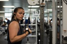 U.S. Air Force Senior Airman Sidnea Bailey, a 35th Operations Support Squadron aircrew flight equipment journeyman, uses a cable crossover machine at Potter Fitness Center, at Misawa Air Base, Japan, Aug. 11, 2019. Bailey expanded her social circle by attending the PFC daily and forging a special bond between her and other gym attendees. (U.S. Air Force photo by Senior Airman Collette Brooks)