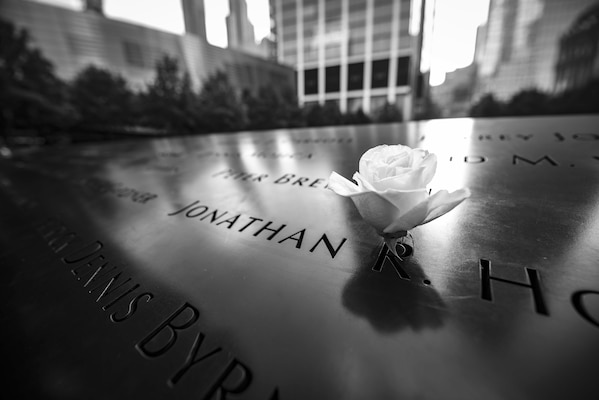 A rose sits in a name carved into a memorial at the 9/11 memorial.