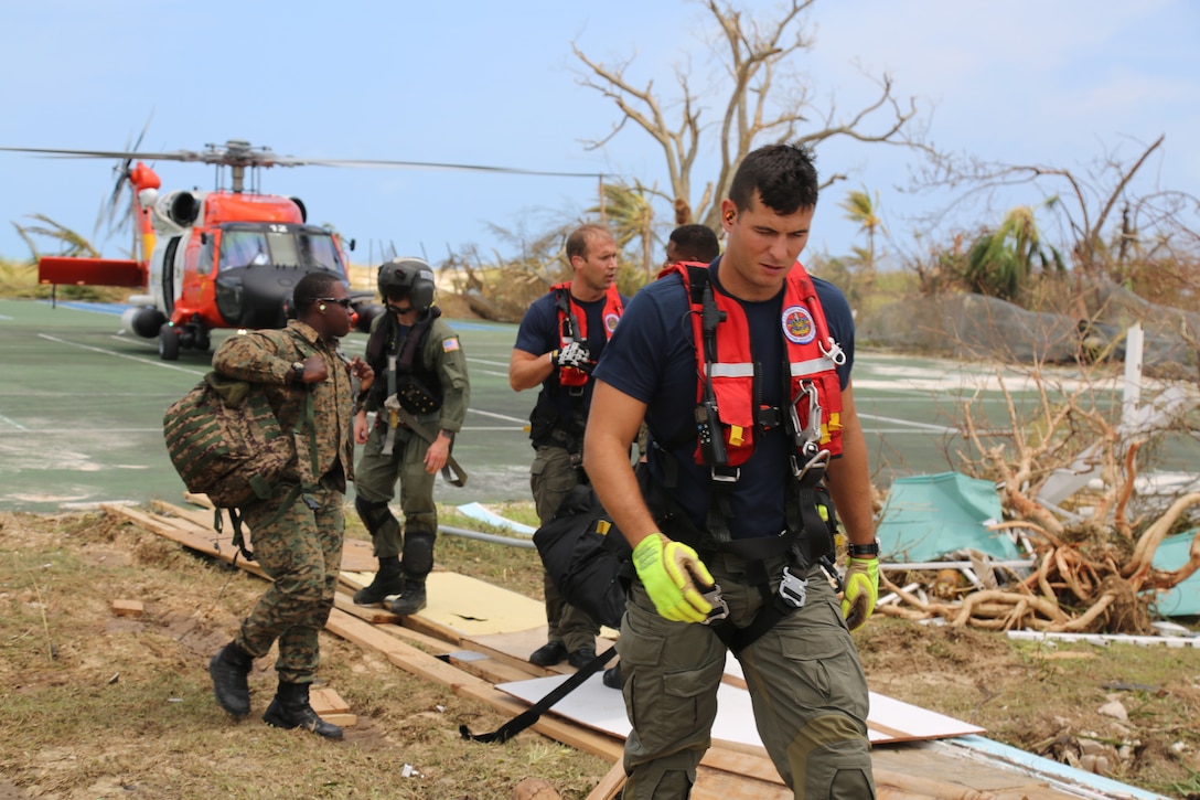 A Coast Guard Air Station Clearwater MH-60 Jayhawk helicopter crew Petty Officer 2nd Class Sam Fuller, Petty Officer 2nd Class Mike Lewis, Petty Officer 2nd Class Jethro Hauser, Ltcdr. Tony Lumpkin and Lt. Travis Rhera in support of search and rescue and humanitarian aid in the Bahamas, Sept. 4, 2019.