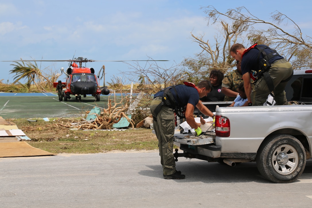 A Coast Guard Air Station Clearwater MH-60 Jayhawk helicopter crew Petty Officer 2nd Class Sam Fuller, Petty Officer 2nd Class Mike Lewis, Petty Officer 2nd Class Jethro Hauser, Ltcdr. Tony Lumpkin and Lt. Travis Rhera in support of search and rescue and humanitarian aid in the Bahamas, Sept. 4, 2019.