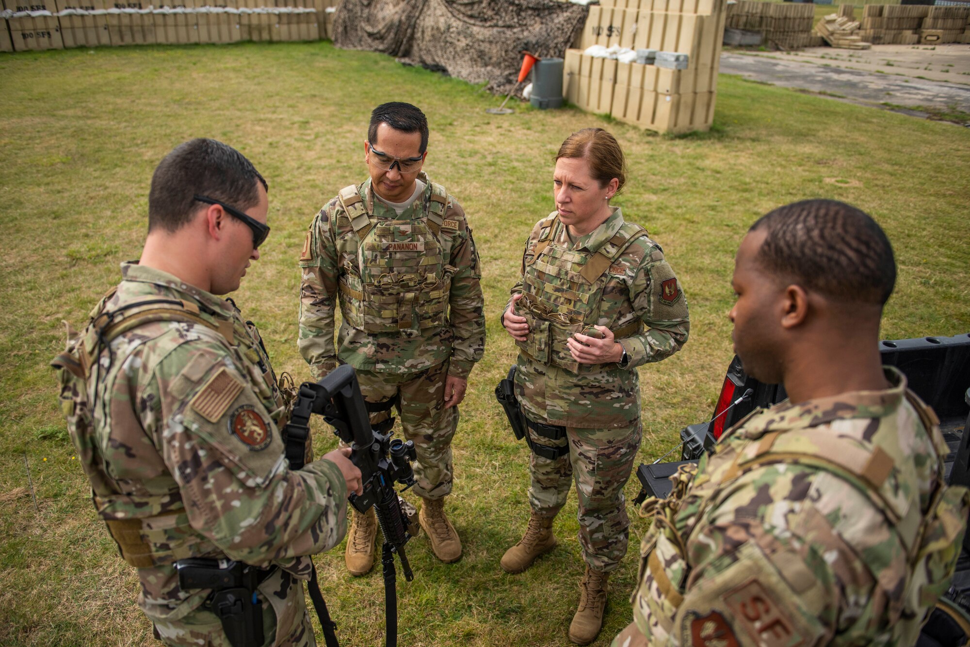 Staff Sgt. Brandon Russell, 100th Security Forces Squadron training instructor, left, shows Col. Troy Pananon, second left, 100th Air Refueling Wing commander, and Chief Master Sgt. Kathi Glascock, 100th ARW command chief, how to safely operate an M4 Carbine during advance shoot, move and communicate training at RAF Mildenhall, England, Aug. 30, 2019. The purpose of the training was for the defenders to demonstrate their advanced combat skills for the commander and command Chief. (U.S. Air Force photo by Senior Airman Luke Milano)