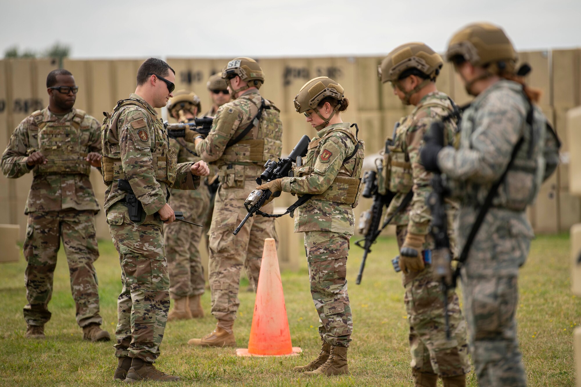 Chief Master Sgt. Kathi Glascock, center, 100th Air Refueling Wing command chief, prepares an M4 Carbine for advanced shoot, move and communicate training with Airmen from the 100th Security Forces Squadron at RAF Mildenhall, England, Aug. 30, 2019.  The purpose of the training was for the defenders to demonstrate their advanced combat skills for the commander and command Chief. (U.S. Air Force photo by Senior Airman Luke Milano)