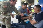 Military personnel practice proper catheter insertion application.
