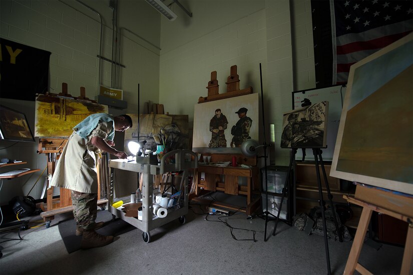 Artist applies paint to palette.