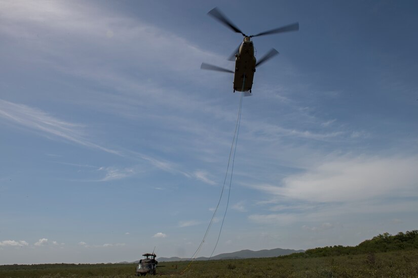 A CH-47 Chinook from the 1st Battalion 228th Aviation Regiment lifts a broken UH-60 Blackhawk to carry it to Liberia Airport in Costa Rica, July 29, 2019. During a mission to support the USNS Comfort, the UH-60 crew performed a precautionary landing in an austere environment in Costa Rica. After inspecting the Blackhawk, the crew determined that aircraft was not safe to fly. Joint service members from Joint Task Force - Bravo worked together, with the assistance of a C-17 Globemaster III from U.S. Transportation Command, to return the broken helicopter back to Soto Cano. (U.S. Air Force photo by Tech. Sgt. Eric Summers Jr.)