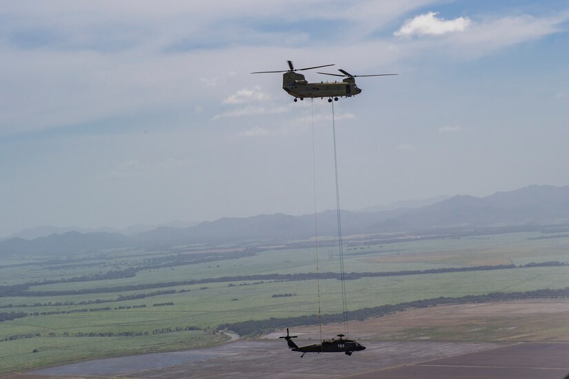 A Ch-47 Chinook from the 1st Battalion 228th Aviation Regiment sling loads a broken UH-60 Blackhawk back to Liberia Airport in Costa Rica, July 29, 2019. During a mission to support the USNS Comfort, the UH-60 crew performed a precautionary landing in an austere environment in Costa Rica. After inspecting the Blackhawk, the crew determined that aircraft was not safe to fly. Joint service members from Joint Task Force - Bravo worked together, with the assistance of a C-17 Globemaster III from U.S. Transportation Command, to return the broken helicopter back to Soto Cano. (U.S. Air Force photo by Tech. Sgt. Eric Summers Jr.)