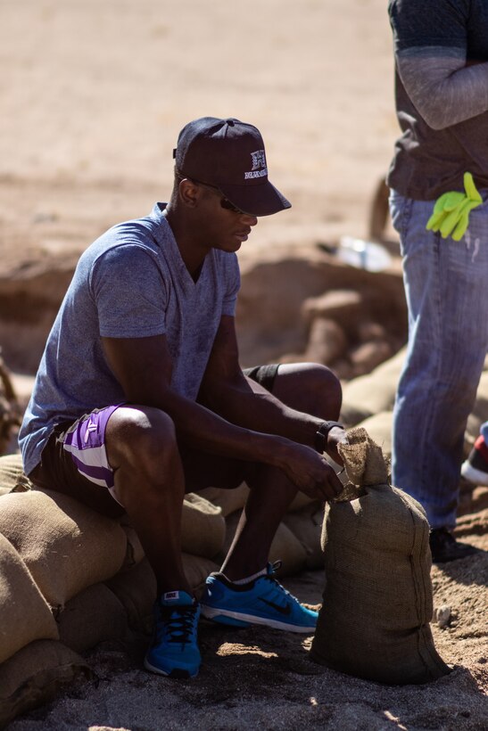 U.S. Marines and sailors with 7th Marine Regiment, 1st Marine Division, fill sandbags in Twentynine Palms, Calif., July 27, 2019. The Marines and sailors volunteered to assist a veteran and current government service employee with repairing his home after it was damaged by a flash flood. (U.S. Marine Corps photo by Pfc. Shane T. Beaubien)