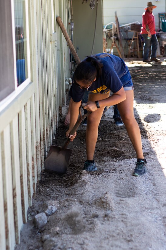 U.S. Navy sailor HP Seaman Danielle with 3rd Battalion, 4th Marine Regiment dig out the mud surrounding Mark Ross’ home in Twentynine Palms, Calif., July 27, 2019. The Marines and sailors volunteered to assist a veteran and current government service employee with repairing his home after it was damaged by a flash flood. (U.S. Marine Corps photo by Pfc. Shane T. Beaubien)