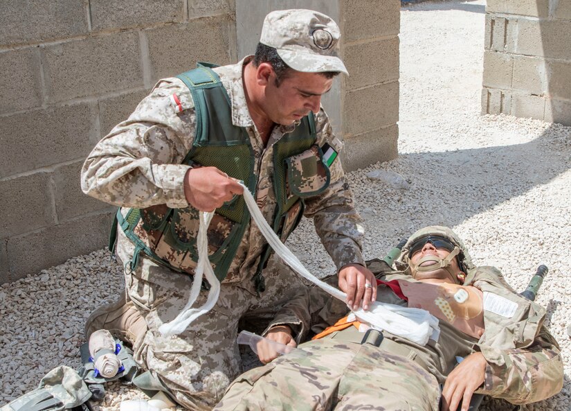 A Jordan Soldier, with 7th Mechanized Battalion, 48th Mechanized Brigade, treats a notional abdominal wound on a U.S. Army Soldier, with 1st Squadron, 102nd Cavalry Regiment, 44th Infantry Brigade Combat Team of the 42nd Infantry Division, New Jersey National Guard, during medical evacuation training, part of the Jordan Operational Engagement Program at Joint Training Center-Jordan August 27, 2019. The Army is optimizing for interoperability with all our allies and partners to strengthen alliances and deliver more effective coalition operations.