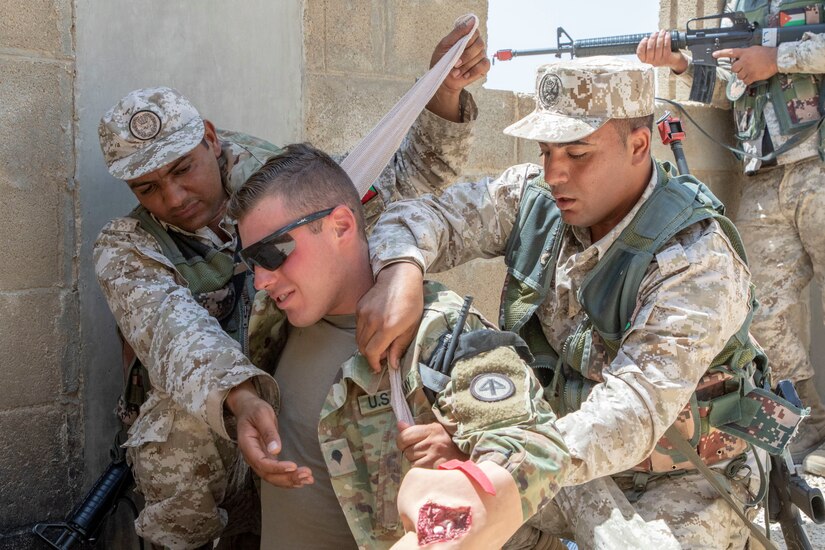 Jordan Soldiers, with 7th Mechanized Battalion, 48th Mechanized Brigade, provide first aid to notional wounds on a U.S. Army Soldier, with 1st Squadron, 102nd Cavalry Regiment, 44th Infantry Brigade Combat Team of the 42nd Infantry Division, New Jersey National Guard, during medical evacuation training, part of the Jordan Operational Engagement Program at Joint Training Center-Jordan August 27, 2019. The Army is optimizing for interoperability with all our allies and partners to strengthen alliances and deliver more effective coalition operations.