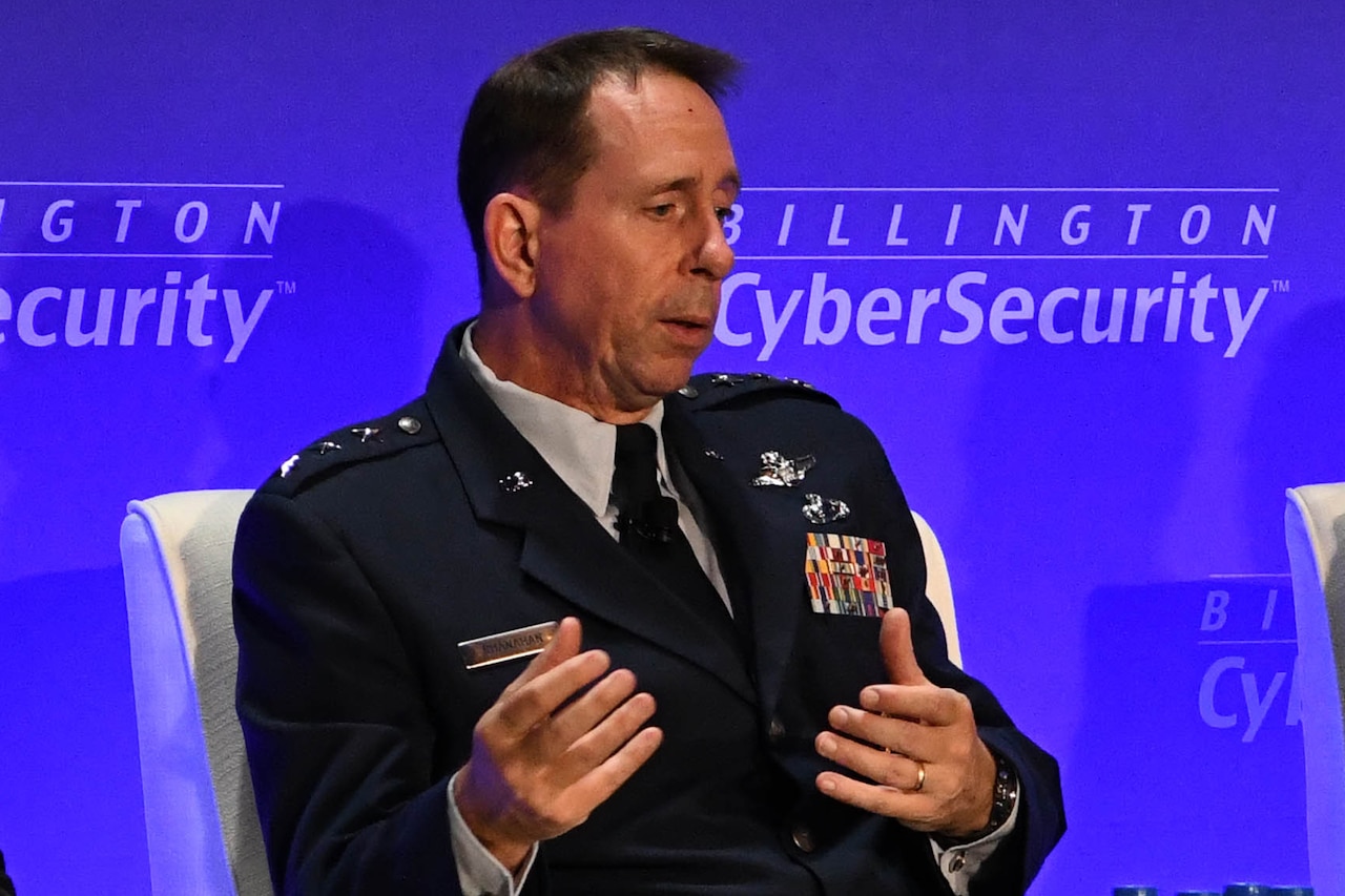 A seated Air Force three-star general gestures while speaking.