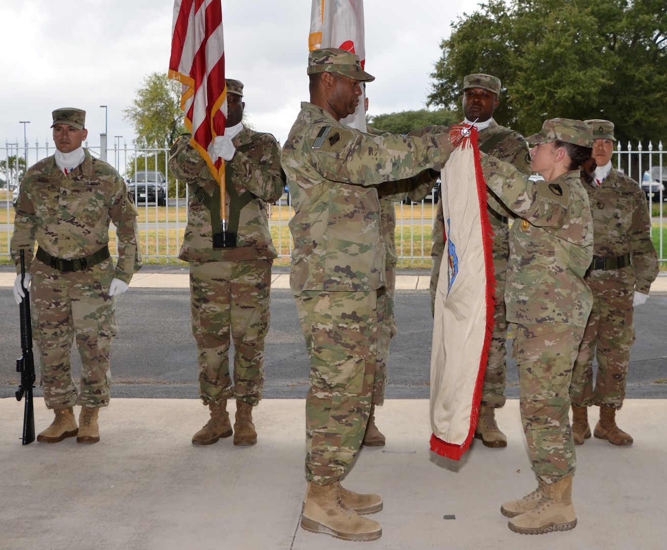 Col. Robert McDonald (left) and Command Sgt. Maj. Sol Nevarezberrios unfurl the 410th Contracting Support Brigade colors during an uncasing ceremony Sept. 5 at Joint Base San Antonio-Fort Sam Houston following the unit’s return from a nine-month deployment to Afghanistan. McDonald is the 410th CSB commander and Nevarezberrios is the brigade command sergeant major.