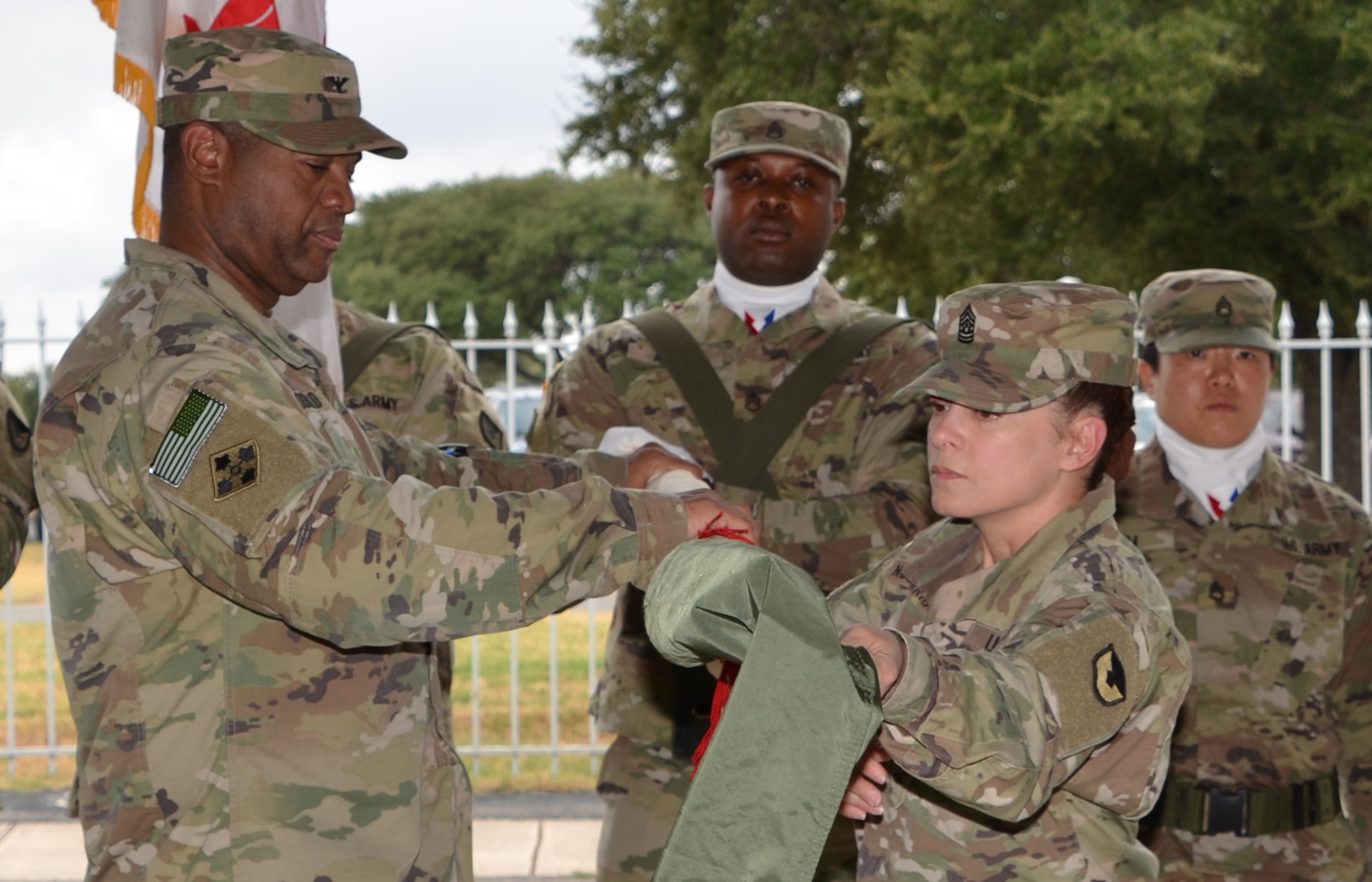 Col. Robert McDonald (left) and Command Sgt. Maj. Sol Nevarezberrios unfurl the 410th Contracting Support Brigade colors during an uncasing ceremony Sept. 5 at Joint Base San Antonio-Fort Sam Houston following the unit’s return from a nine-month deployment to Afghanistan. McDonald is the 410th CSB commander and Nevarezberrios is the brigade command sergeant major.