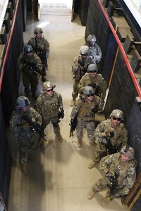 Soldiers from Company D, 2nd Battalion, 130th Infantry Regiment, Illinois Army National Guard, directs attention to a range safety officer as they receive feedback after a room clearance drill during Rising Thunder 19, at Yakima Training Center in Yakima, Washington, Sept. 1, 2019.