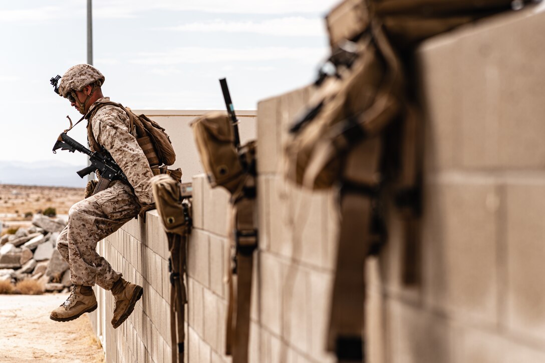 Marine with 3rd Battalion, 7th Marine Regiment, 1st Marine Division, scales wall during counter-IED training at Marine Corps Air Ground Combat Center, Twentynine Palms, California, July 25, 2019 (U.S. Marine Corps/Colton Brownlee)