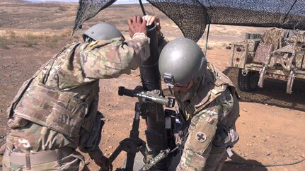 Soldiers from Headquarters and Headquarters Company, 2nd Battalion, 130th Infantry Regiment, based in Marion, Illinois, adjust a 120mm mortar tube during Rising Thunder 19.